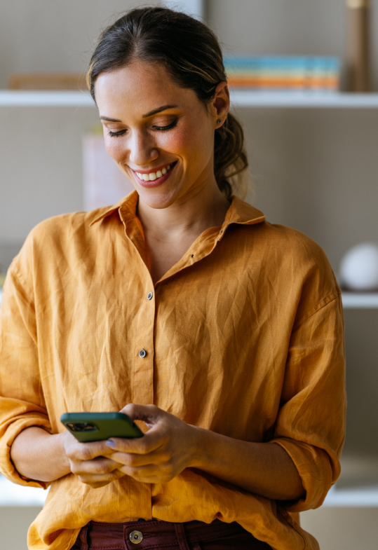 smiling woman looking at phone screen